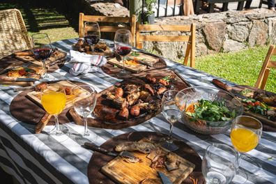 Family outdoors lunch table with delicious asado on it