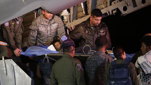 Military personnel unload from a plane one of four Indigenous children who were missing after a deadly plane crash at the military air base in Bogota, Colombia.