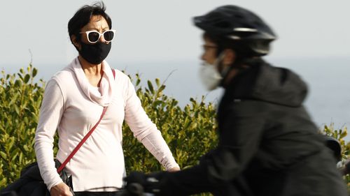 A woman, wearing a face mask, walks along St Kilda on July 25, 2020 in Melbourne, Australia.