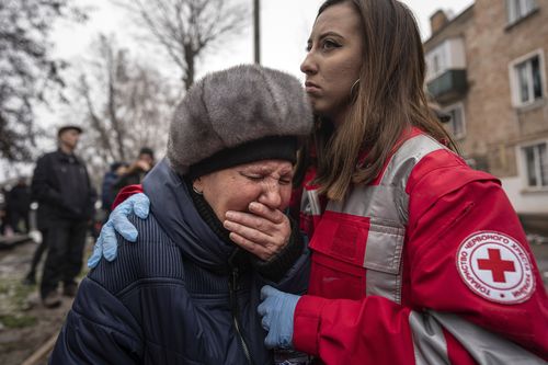 A woman cries in front of the building which was destroyed by a Russian attack in Kryvyi Rih, Ukraine, Friday.