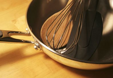 whisk with wooden spoon in frying pan