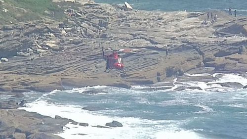 The two survivors clung to a rock face after swimming to safety. (9NEWS)