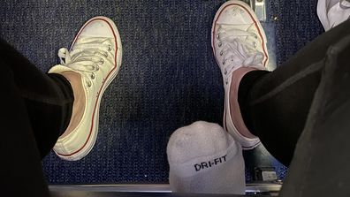 Toes peeking under a seat on a plane, via Reddit