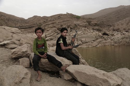 In this July 30, 2018, photo, a 17 year-old boy holds his weapon in High dam in Marib, Yemen.