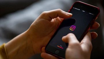 The logo of the Instagram app is seen on the screen of a smartphone in 2021.