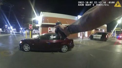 In this image taken from Oct. 2, 2022 police body camera video and released by San Antonio Police Department, Erik Cantu drives away as San Antonio Police officer James Brennand shoots his pistol at the car in a fast food restaurant parking lot in San Antonio, Texas. 