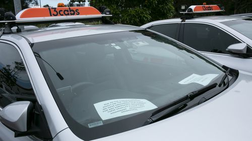 Coronavirus. Cabs with their number plates removed sit idle in Tempe Reserve. Most have a sign on their dash that reads "due to the coronavirus effect on the taxi industry we have grounded our fleet..." Thursday 9th April 020. photo Ryan Stuart