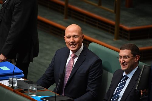 Peter Dutton smiles through the jeers at Question Time today.
