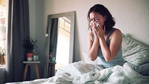 Frau im Bett mit Grippe