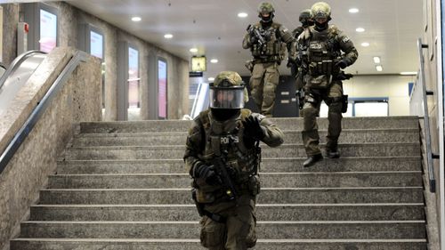 Heavily armed police run through a stairwell at a train station in Munich. (AFP)