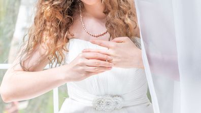 Stock image bride in wedding dress pulls off engagement ring