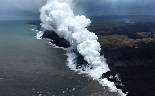 Lava sends up clouds of steam and toxic gases as it enters the Pacific Ocean as Kilauea Volcano continues its eruption cycle near Pahoa on the island of Kilauea. (AP).