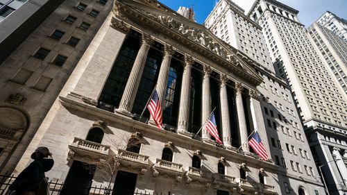 A pedestrian walks past the New York Stock Exchange.