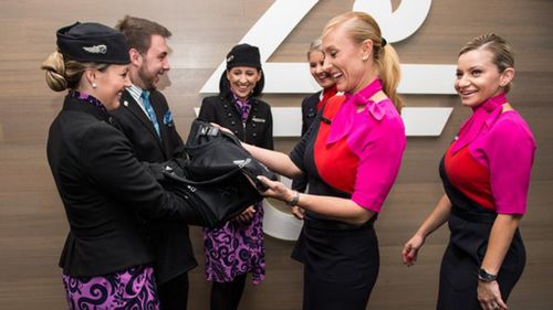 Air New Zealand staff (left) handing the jerseys over to Qantas crew. (Twitter: @FlyAirNZ)