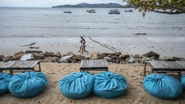  People are seen strolling by the sea from a beach bar in Phuket, Thailand