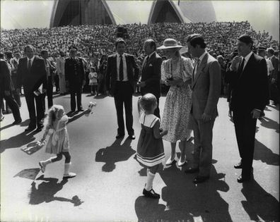 A little girl races in to present her tribute to the Princess of Wales, outside the Sydney Opera House. 