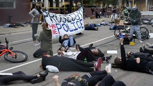 Protesters hold a die-in outside the Hennepin County Family Justice Center where four former Minneapolis police officers appeared at a hearing Friday, Sept. 11, 2020, in Minneapolis