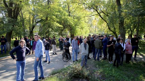 Local people gather near a school where a bomb is believed to have been detonated in Crimea, Russia.
