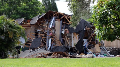 Debris is strewn from a partially collapsed home in Land O'Lakes on Friday. (AAP)