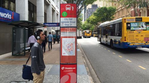 A commuter in Brisbane looks at a bus timetable