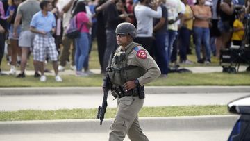 A law enforcement officer walks as people are evacuated from a shopping centre where a shooting occured Saturday, May 6, 2023, in Texas. 