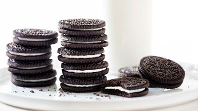 Oreo cookies stacked with milk on white background