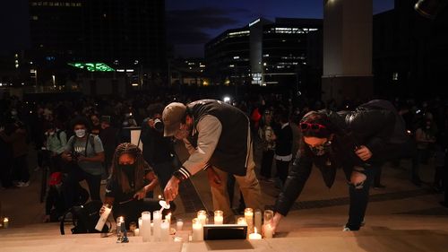 People light candles to honor cinematographer Halyna Hutchins. 