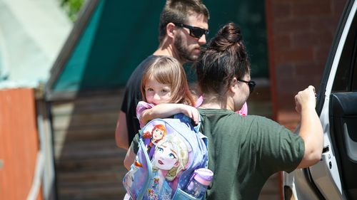 Cleo Smith is carried inside a friend's house by her mother in Carnarvon.