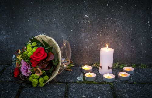 lowers and candles lie in front of the International Criminal Tribunal for the former Yugoslavia, placed after the death of Slobodan Praljak. (AAP)