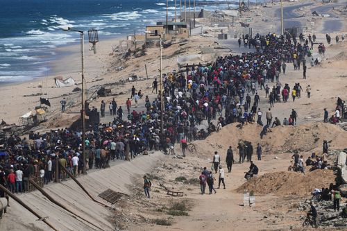 Displaced Palestinians walk along the coastal road near Wadi Gaza in the central Gaza Strip