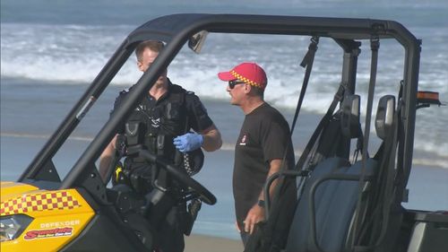 A man in his 20s has died and two others were taken to hospital, after three men were pulled from the water at The Spit on the Gold Coast.