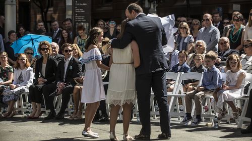 Katrina Dawsons's daughter Chloe hugs her father Paul Smith during the unveiling. (AAP)