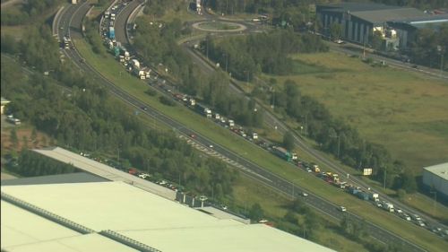 Traffic queued more than 10km on M7 Motorway in Sydney's south-west after bobcat falls off back of truck