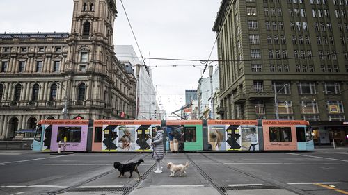 A person crosses Bourke Street in Melbourne, Australia. Victoria is under strict lockdown.