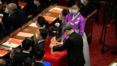 A delegate casts his vote during a session of China's National People's Congress