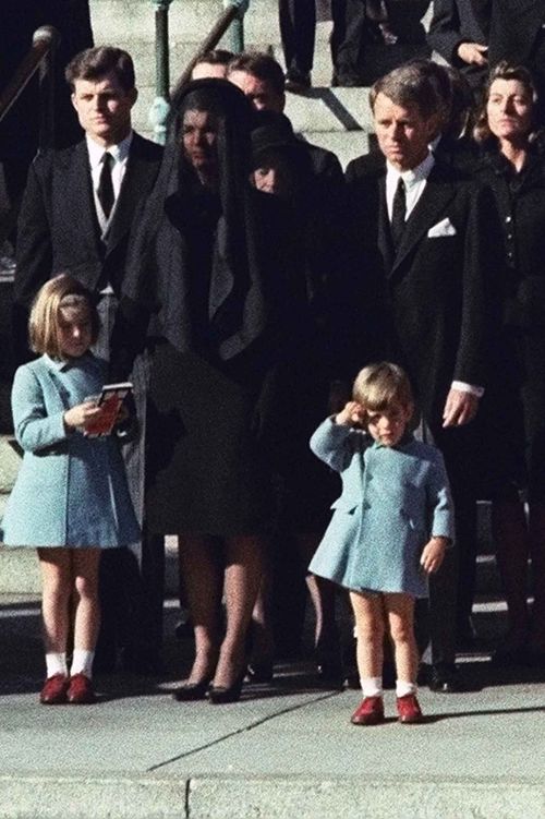 John F Kennedy Jr salutes his father's coffin at his funeral in 1963, alongside his uncles Ted (left) and Robert (right), and mother Jackie.