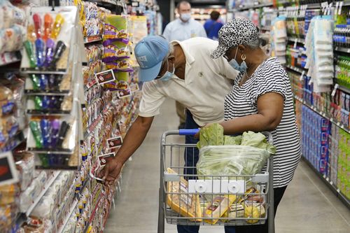FILE - Ray Carter, left, and Bobbie Carter right, shop at the new Homeland grocery store, Wednesday, Sept. 1, 2021, in Oklahoma City.  Consumers facing higher prices for products made with corn and wheat could be in for more pain as global supplies tighten because of Russias invasion of Ukraine. Wheat and corn prices have each jumped more than 20% so far this year, surpassing their gains for all of 2021.  (AP Photo/Sue Ogrocki, File)
