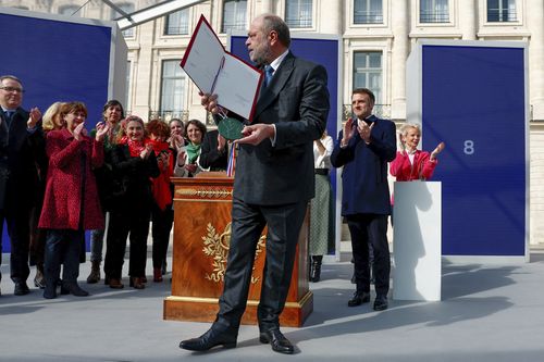 Justice Minister Eric Dupond-Moretti and French President Emmanuel Macron, background right, attend a ceremony to seal the right to abortion in the French constitution, on International Women's Day, at the Place Vendome, in Paris, France March 8, 2024. 