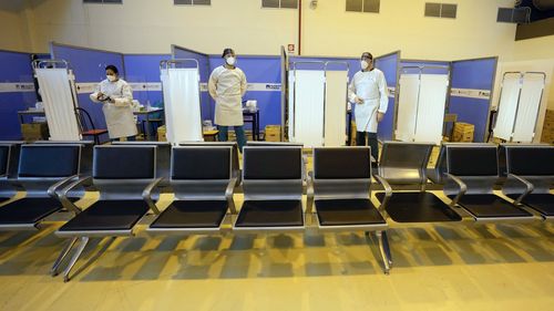 Medical personnel wait for passengers coming with an Air China flight from Guangzhou, China, in a COVID-19 testing area set at Rome's Leonardo da Vinci international airport in Fiumicino, Thursday, December 29, 2022 after Italy made coronavirus tests mandatory for all airline passengers arriving from China. 