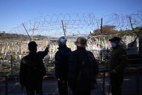 Los visitantes pasan cercas de alambre decoradas con cintas con mensajes que desean la paz para las dos Coreas en el Pabellón Imjinjak en Paju, Corea del Sur, el viernes 4 de noviembre de 2022.  