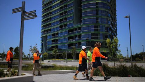 Construction workers outside Olympic Park's Opal Tower.