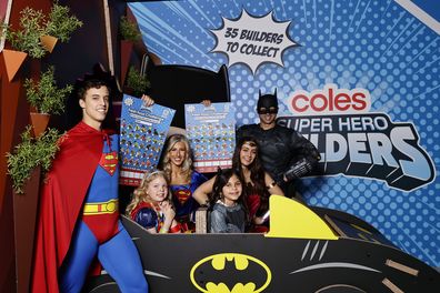 Primary school students pose with super heroes during the Coles Super Hero Builders collectables campaign launch