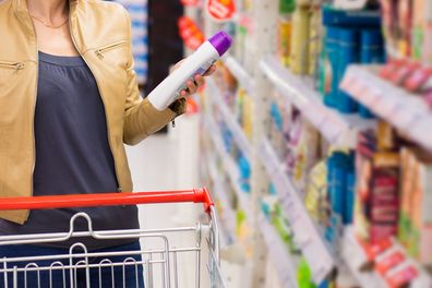 Woman buying supermarket shampoo stock image
