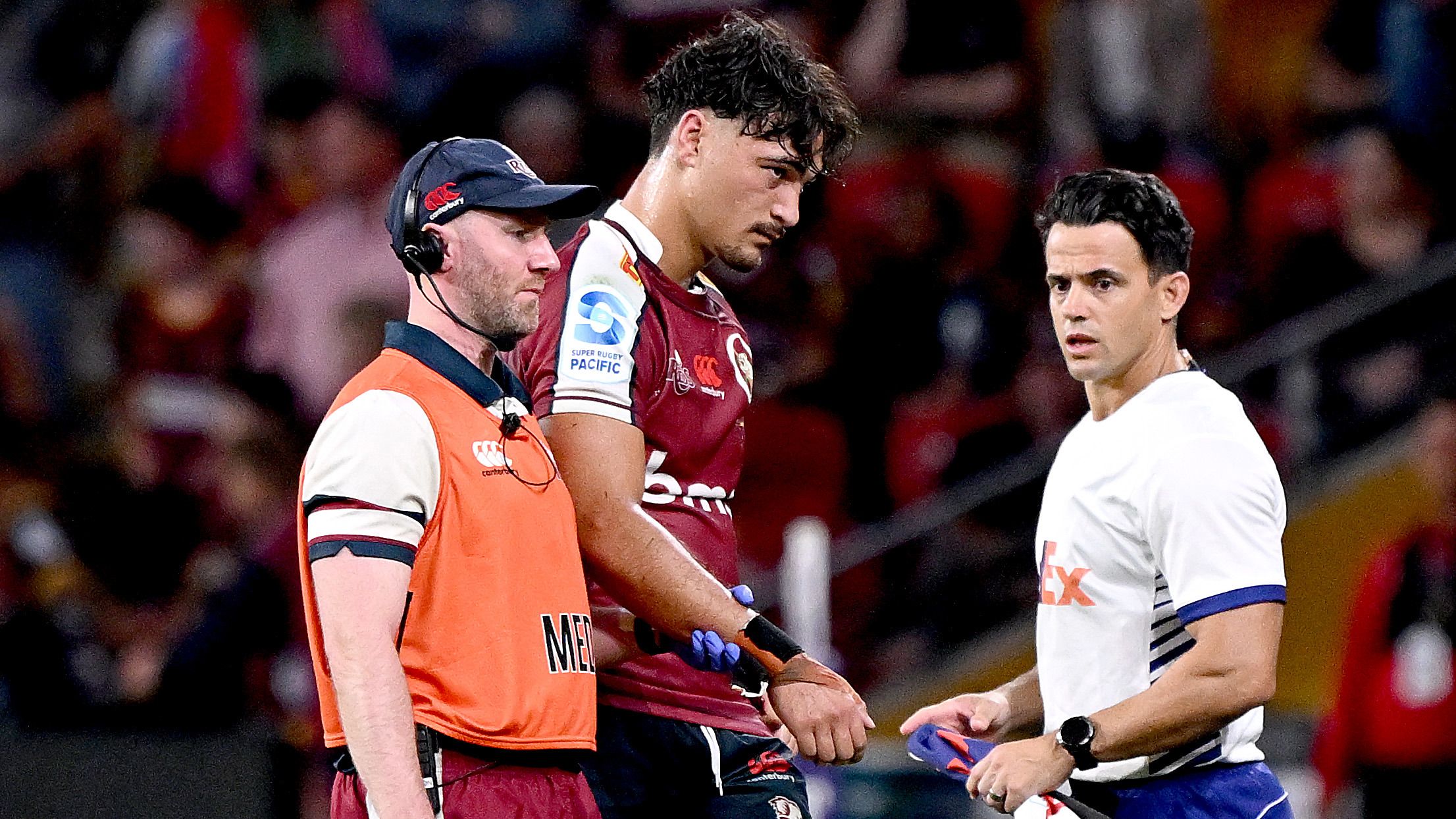 Jordan Petaia of the Reds is taken from the field injured during the round nine Super Rugby Pacific match against the Highlanders.
