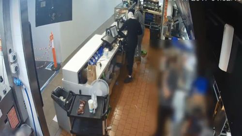 The McDonald's staff stood back as the men ransacked the cash registers (Supplied)