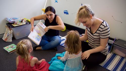 The therapists tell twins Dearne and Marissa a story. (Ehsan Knopf/9NEWS)