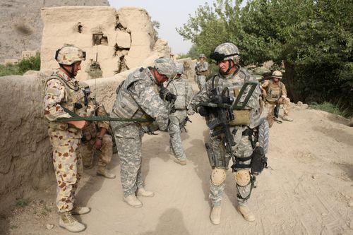 US and Australian soldiers from US-led Task Force Paladin get ready to search for mines in 2008 with a metal detector during an operation to search three compounds and look for weapons in Salavat, Panjawi Province, Afghanistan.