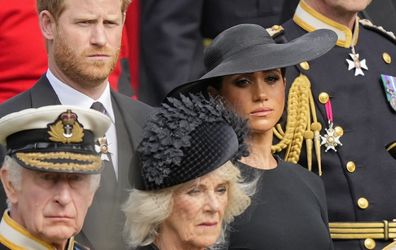 Meghan Markle is seen tearing up with Prince Harry as they watch the Queen's coffin placed into the hearse.