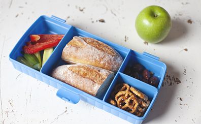 School lunch bread roll with pretzels and vegetable sticks
