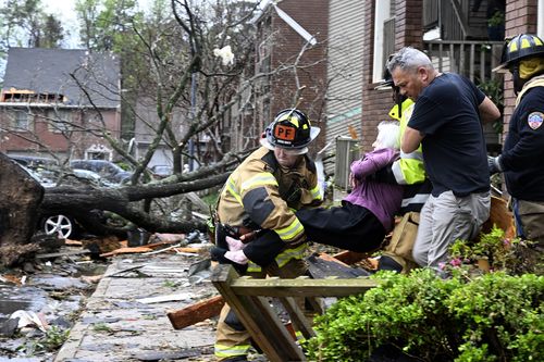 Les pompiers transportent une femme hors de son appartement après que son complexe a été endommagé par une tornade, le vendredi 31 mars 2023 à Little Rock, Ark.